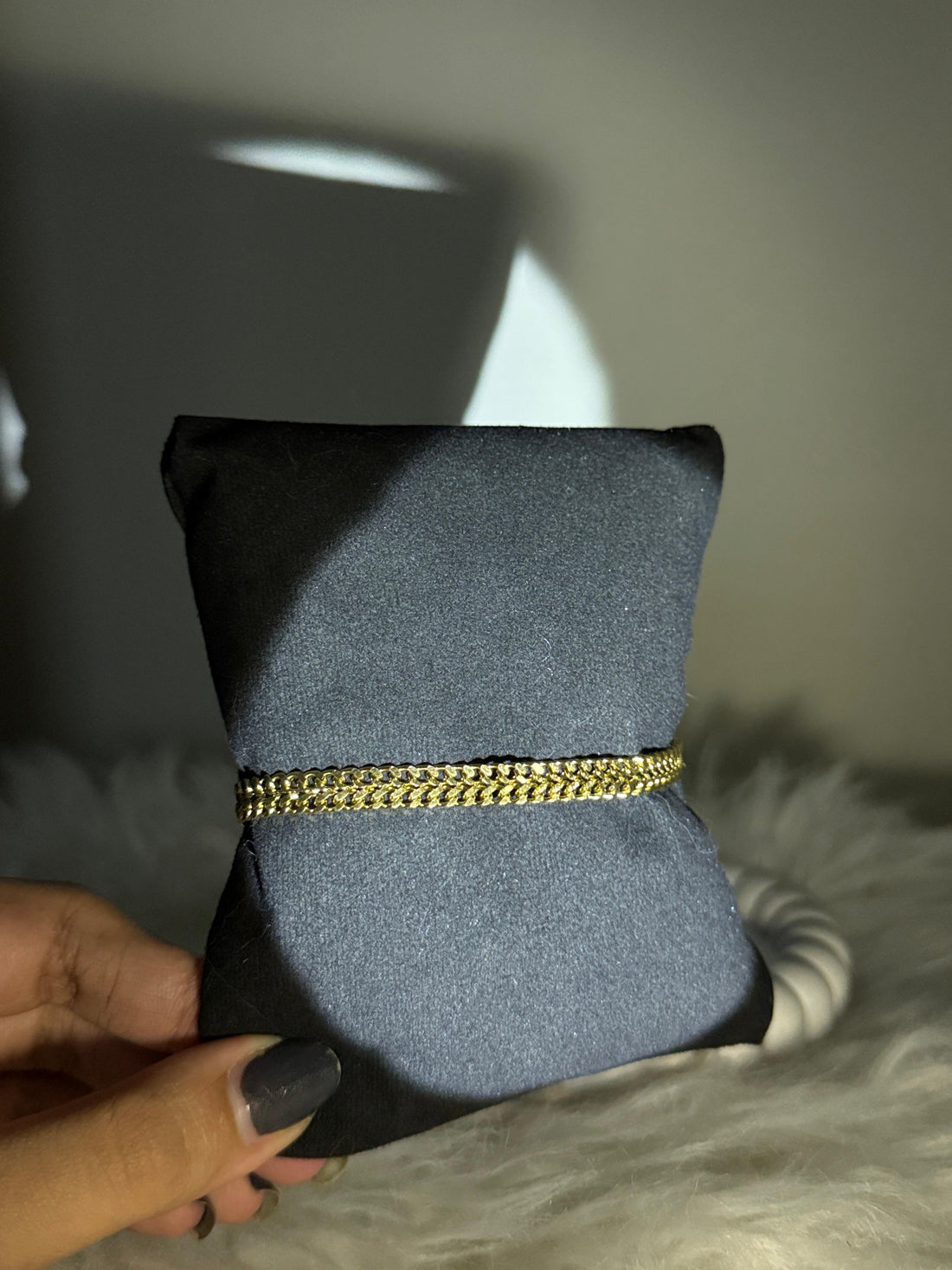 Gold-tone stainless steel chain bracelet with adjustable clasp on a white background
