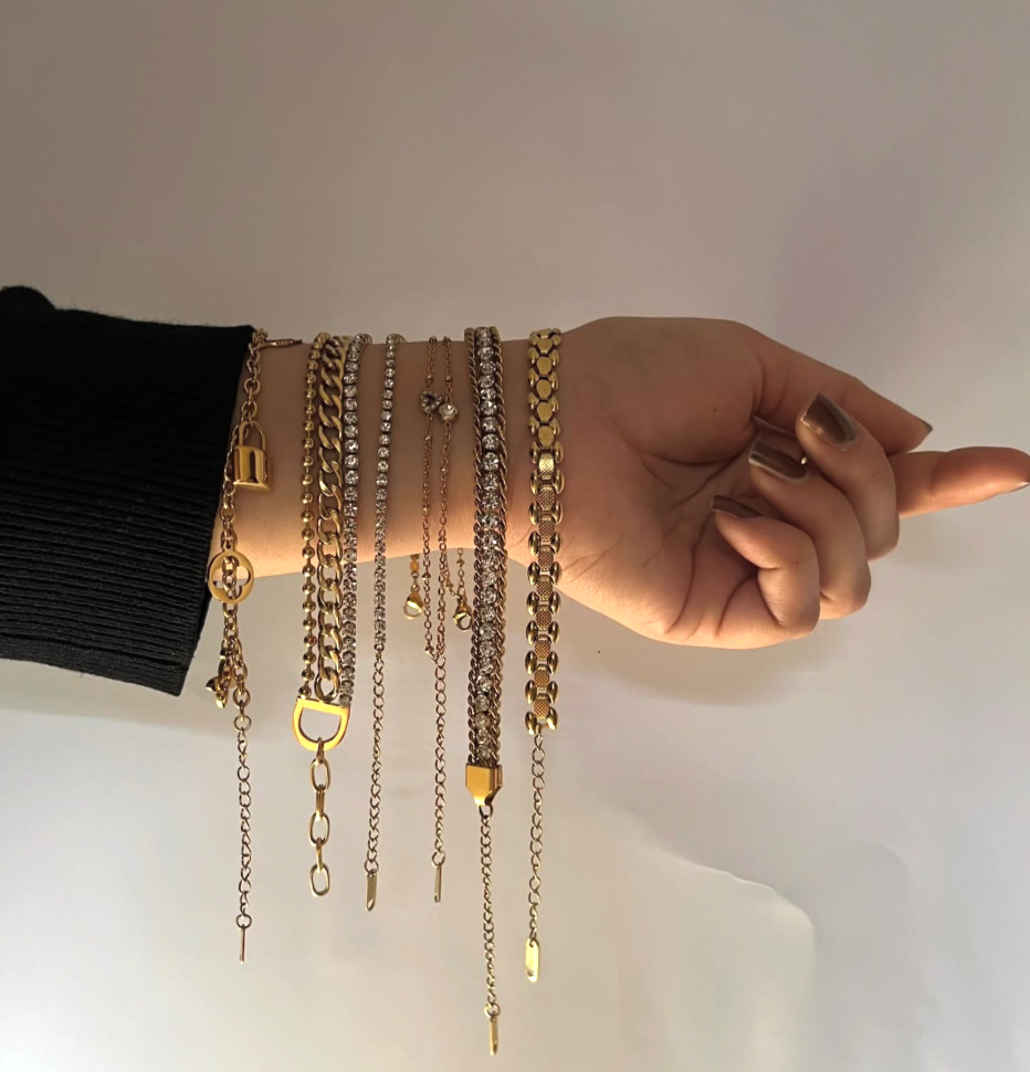 Woman's hand wearing layered gold and silver stainless steel bracelets, jewelry display