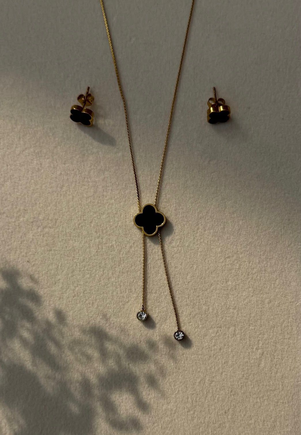 Gold stainless steel necklace with black clover pendant and matching stud earrings